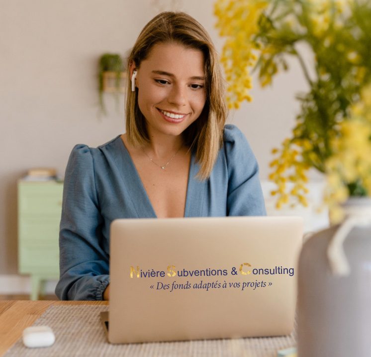 Femme souriante avec un ordinateur portable, fleurs jaunes en arrière-plan.